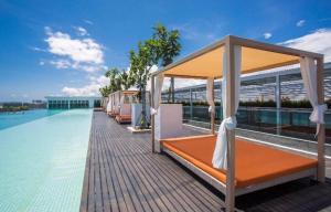 1 cama en una terraza junto a la piscina en Leisure homestay@Sutera Avenue 2-1007, en Kota Kinabalu