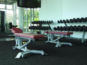 un gimnasio con 2 sillas y un estante de pesas en Leisure homestay@Sutera Avenue 2-1007, en Kota Kinabalu
