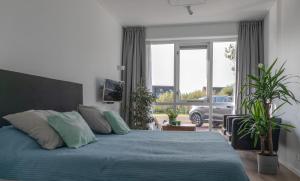 a bedroom with a bed with blue sheets and a window at Buitenplaats Wergea in Naarderburen