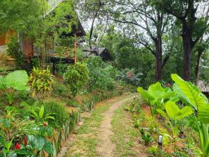 un camino de tierra que conduce a un jardín con plantas en Littleduck bungalow Koh Chang Ranong, en Koh Chang
