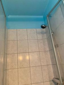 um chuveiro com uma porta de vidro e um piso de azulejo em Hotel Pension Schienfatt am Dornumersieler Tief em Dornum