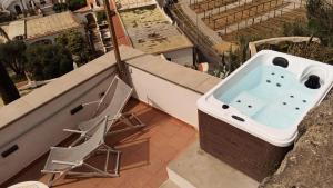 a bath tub sitting on a balcony with a chair at Eremo di Montevergine Ischia Apartments in Ischia