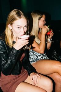 dos mujeres sentadas una al lado de la otra tomando bebidas en The Village Cairns, en Cairns