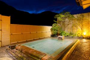 a swimming pool in a backyard at night at Tachibanaya in Tsuruoka