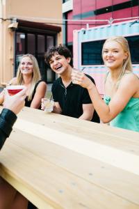 un grupo de personas sentadas en una mesa en The Village Cairns, en Cairns