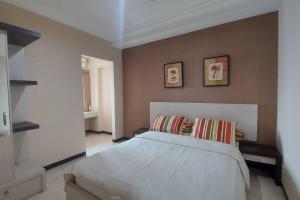 a bedroom with a large white bed with two pillows at Galeri Ciumbuleuit Apartment 1 2BR 1BA - code 26A in Bandung