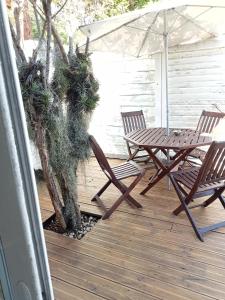 un patio con 2 sillas, una mesa y una sombrilla en Yaka, en Saint-Paul