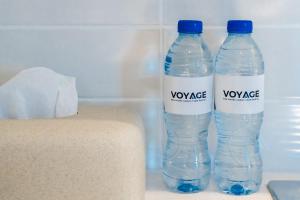 duas garrafas de água sentadas num frigorífico em Voyage Water Edge Studio em Abu Dhabi