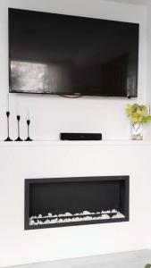 a fireplace with a flat screen tv above it at Apartamento Manizales Colombia in Manizales