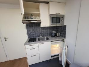 Il comprend une petite cuisine équipée d'un évier et d'un four micro-ondes. dans l'établissement Private Apartment., à Hilversum