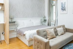 a bedroom with a bed and a couch at Anytime Holiday- Muzeum Apartments in Prague