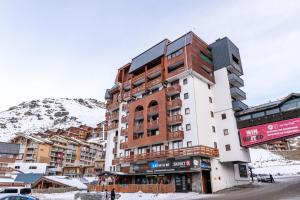 a building in the middle of a snow covered mountain at Résidence Altineige - 3 Pièces pour 6 Personnes 31 in Val Thorens