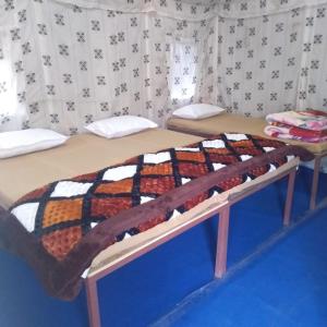 a bed in a room with a blanket on it at Valley view camps &cottages in Nainital