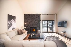 a living room with a white couch and a fireplace at Fairway Nine 4369 - Updated Condo in the Heart of Elkhorn Resort in Sun Valley