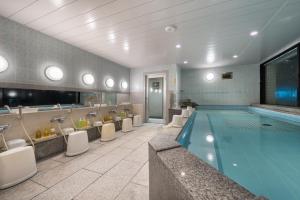 a bathroom with a swimming pool and sinks and toilets at Hotel Morning Box Osaka Shinsaibashi in Osaka