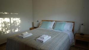 1 dormitorio con 1 cama con toallas en El Higuerón (Serranía de Ronda), en Jimera de Líbar