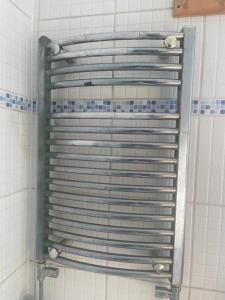 a metal rack in a shower in a bathroom at E-Sky Homes in South Norwood