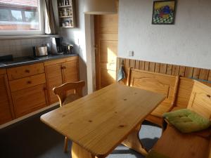 - une table et des chaises en bois dans la cuisine dans l'établissement Warthe - Mitten in der Natur, à Warthe