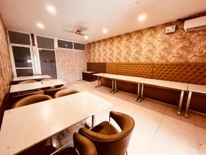 uma sala de jantar com mesas, cadeiras e bancos em The Peral Lodge - A beautiful lavish & luxuries Family Hotel em Zirakpur