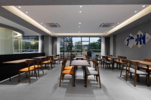ein Restaurant mit Tischen, Stühlen und Fenstern in der Unterkunft Guangzhou Yunjia Hotel - Airport Terminal 2 in Guangzhou