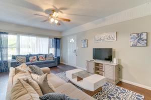 a living room with a couch and a tv at Galveston Vacation Rental - Walk to the Beach! in Galveston