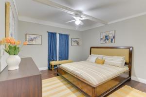 a bedroom with a bed and a vase of flowers on a table at Galveston Vacation Rental - Walk to the Beach! in Galveston