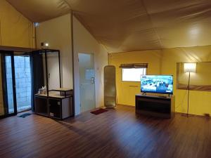 un salon avec une télévision à écran plat dans une tente dans l'établissement De Bloem Lake View Pangalengan, à Pengalongan