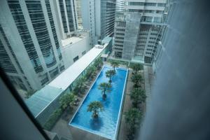 an overhead view of a pool with palm trees and buildings at Soho Suites KLCC by Minsha in Kuala Lumpur