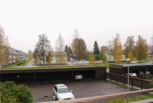a parking lot with a white car parked under a bridge at Kalustettu yksiö keskustassa in Raahe