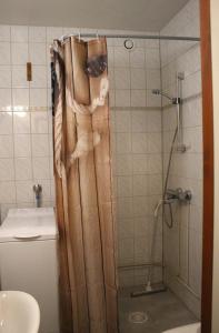 a shower with a wooden shower curtain in a bathroom at Kalustettu yksiö keskustassa in Raahe