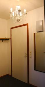Habitación con puerta y lámpara de araña. en Kalustettu yksiö keskustassa en Raahe