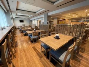 a dining room with wooden tables and chairs at Route Inn Grantia Naha in Naha