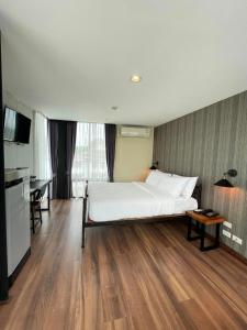 - une chambre avec un grand lit blanc et un bureau dans l'établissement Chiang Mai Thai House,Thapae, à Chiang Mai