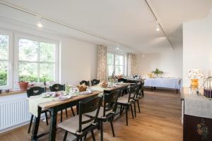 a dining room with a long table and chairs at Pension Tannenheim in Schluchsee