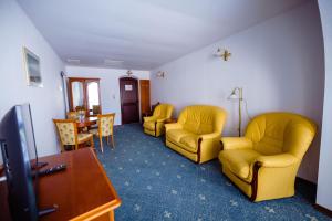 Complex Vața Băi في Vaţa de Jos: غرفة انتظار وكراسي صفراء وطاولة