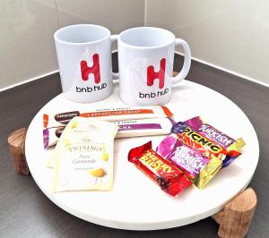 ein Tisch mit zwei Kaffeetassen und Snacks darauf in der Unterkunft Supa Sized 3 bedroom 2 bath in Gold Coast