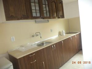 a kitchen with a sink and wooden cabinets at Guest House Liliya in Sozopol +71 photos