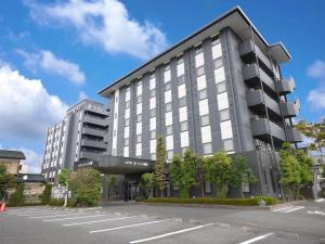 un gran edificio con un estacionamiento delante de él en Hotel Route-Inn Yuki, en Yuki