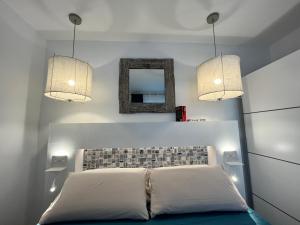 a bedroom with a bed with two lights and a mirror at Barbican in Playa Honda