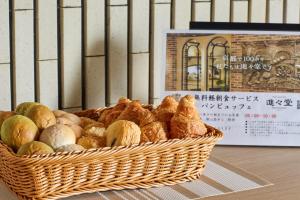- un panier de pain et de viennoiseries sur une table dans l'établissement Riverside Arashiyama, à Kyoto