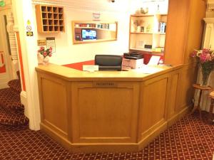 a reception desk in a room with a laptop on it at Welbeck Hotel - Close to Beach, Train Station & Southend Airport in Southend-on-Sea