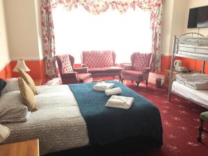 a bedroom with a bed with two chairs and a couch at Welbeck Hotel - Close to Beach, Train Station & Southend Airport in Southend-on-Sea