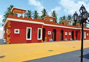 um edifício vermelho com uma luz de rua em frente em World Cat Beach & Resort เวิลด์แคท บีช แอนด์ รีสอร์ท em Bang Saphan