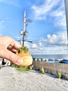 a person holding a piece of food in their hand at Aewol Torini in Jeju