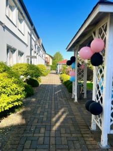 una pasarela de ladrillo con globos conectados a un edificio en Royal House, en Białogard