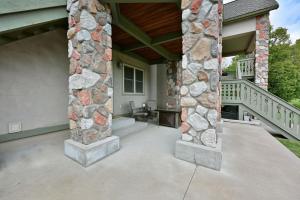 a large patio with a stone wall and a porch at Unit 109 2 BDRM 2 BA condo in Birchwood