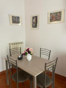 een houten tafel met stoelen en een vaas met bloemen erop bij Franco's Home in Florence