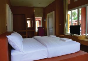 1 cama blanca grande en un dormitorio con TV en World Cat Beach & Resort เวิลด์แคท บีช แอนด์ รีสอร์ท, en Bang Saphan