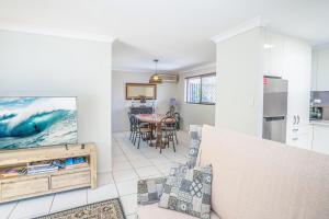 a kitchen and living room with a table and a tv at 3BR Family Oasis: Pool, BBQ, Central Gold Coast Fun! in Gold Coast