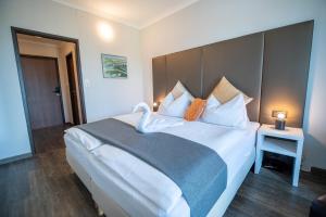 a bedroom with a large white bed with pillows at Hotel Marc Aurel in Petronell